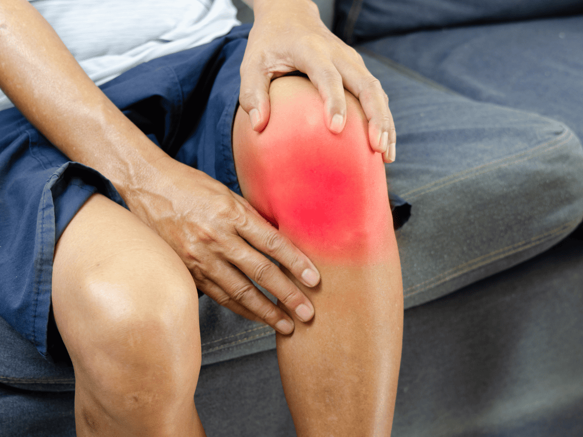 HIIT injury | Fit Fun And Over 40 woman sitting on couch with knee injury