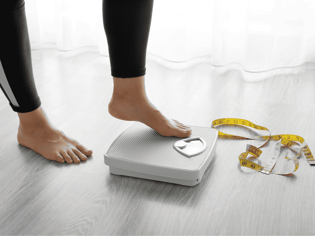 weight loss from HIIT | Fit Fun And Over 40 woman stepping on scale