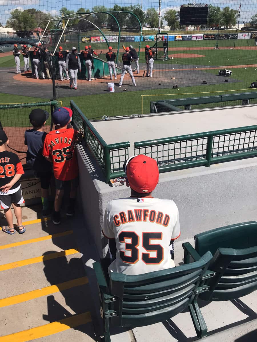 Children waiting to ask for autographs while players on the field